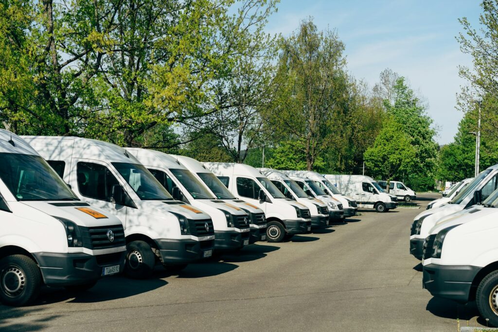 Row of white vans parked in a lot, representing a business vehicle fleet