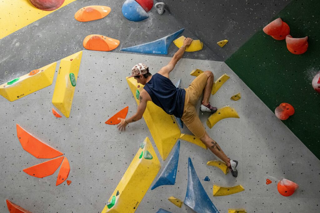 Man bouldering on a climbing wall, tackling a route like those the grades describe