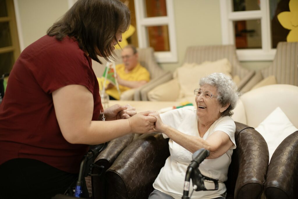 Caregiver assisting an elderly woman who is using a walker, illustrating everyday care assistant work
