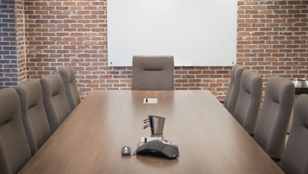 Conference room with a projector screen, chairs and a large table in a modern space
