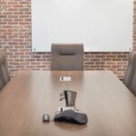 Conference room with a projector screen, chairs and a large table in a modern space