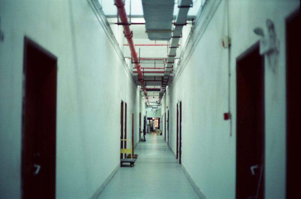 Long, empty corridor with multiple doors, the kind of route needing clear evacuation planning