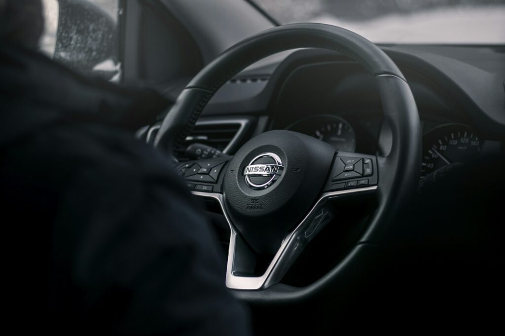 Black Nissan steering wheel, the part of the car where drivers notice steering play