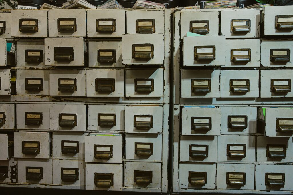 Rows of old filing cabinets with labels, a traditional way of keeping records