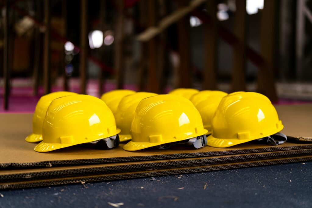 Several bright yellow hard hats neatly lined up, a symbol of workplace safety