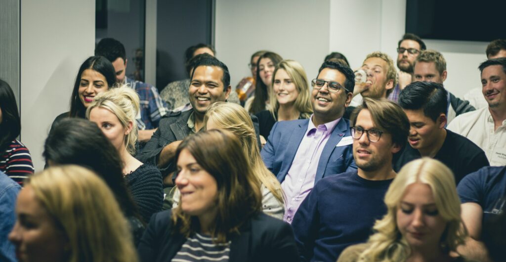 Diverse group of adults listening attentively during a professional seminar or workshop at a work event