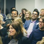 Diverse group of adults listening attentively during a professional seminar or workshop at a work event