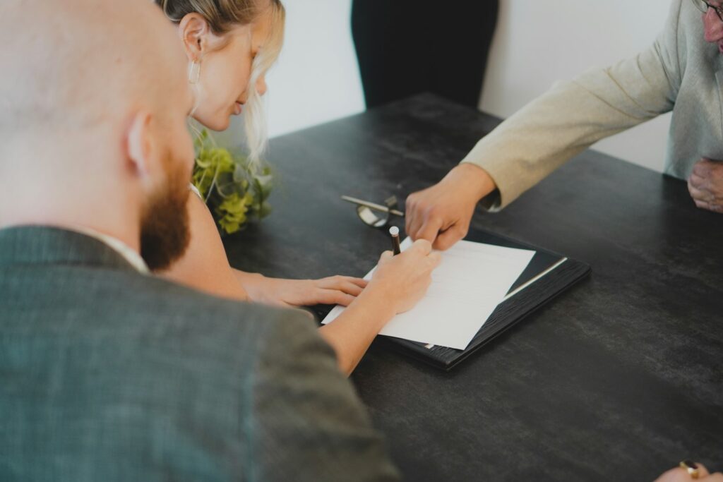 Couple signing a document at a desk, as when dealing with an estate's paperwork