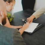 Couple signing a document at a desk, as when dealing with an estate's paperwork
